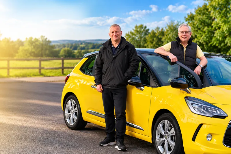 Yello Driving School instructors standing beside a yellow learner car